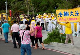 学员为数十车中国大陆来西子湾的游客展演法轮功祥和优美的五套功法